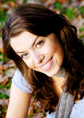 A young woman smiling confidently with perfect porcelain veneers.