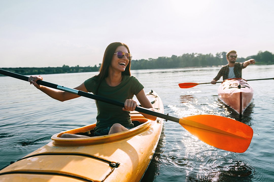 A young woman smiling while kayaking after full mouth reconstruction in Billings.