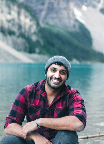 A smiling man sits by a lake happy after TMJ treatment in Billings, MT.