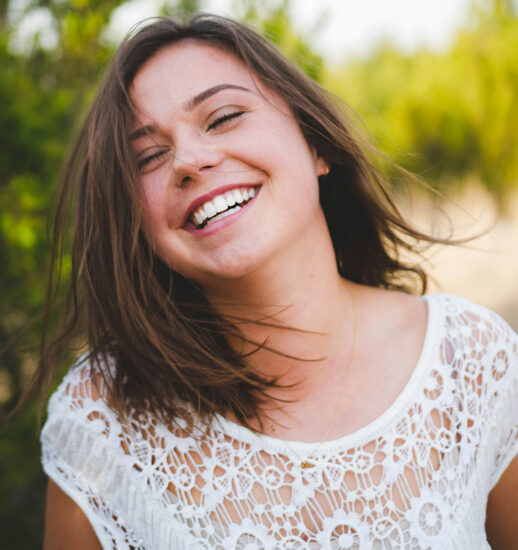 Young girl smiles big outside after Invisalign aligners in Billings, MT